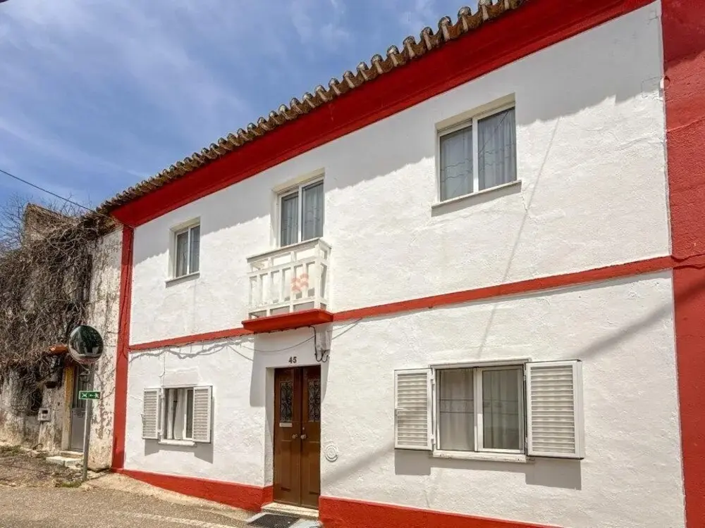Two-storey white village house with red trim in Gavião, Portalegre